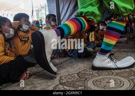 Bandung, Indonesia. 05 ottobre 2021. I bambini sopravvissuti al cancro hanno visto guardare la Comunità di Clown di Necis in Rumah Pejuang Kanker Ambu.The Comunità di Clown di Necis insieme con Persit Kartika Chandra Kirana Branch IX Pussenkav PG Kodiklat ad ha tenuto una parodia della prevenzione di COVID-19 per intrattenere i bambini con i superstiti del cancro. Credit: SOPA Images Limited/Alamy Live News Foto Stock