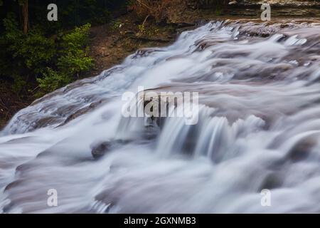 Acqua che scorre pesantemente sulle rocce a cascata Foto Stock