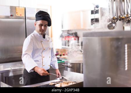Lo chef prepara il cibo, la frittura sul grill. La vendita e il concetto di cibo Foto Stock