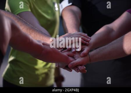 Gruppo di corridori sani dando alta cinque per ogni altro mentre celebriamo il successo dopo una sessione di formazione. Foto Stock