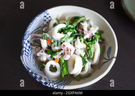 Il basilico fritto lascia il calamaro in una ciotola bianca Foto Stock