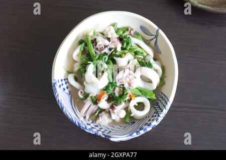 Il basilico fritto lascia il calamaro in una ciotola bianca Foto Stock