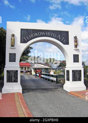 Arco d'ingresso al Whaka Village a Rotorua, Nuova Zelanda. Il villaggio termale vivente ospita Maori da decenni ed è aperto ai turisti per esperienze interculturali. L'arco commemorativo è sia l'ingresso che l'uscita del villaggio commemorando i soldati caduti i cui nomi sono inscritti in fondo all'arco. Foto Stock