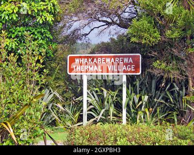 Il cartello Whakarewarewa Thermal Village fuori dal villaggio vivente Maori a Rotorua, Nuova Zelanda. Un'importante attrazione turistica, il villaggio è stato casa, per decenni, di Maori che mostrano come vivono con gli elementi naturali del suo paesaggio vulcanico. Foto Stock
