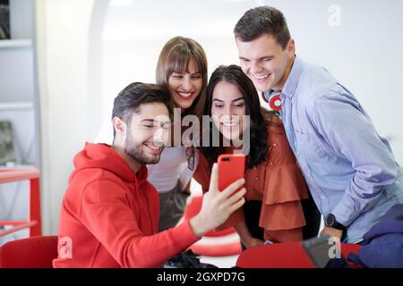 Selfie Time!International students with beaming smiles are posing for selfie shotWoman students wcerto prendere appunti da un libro in biblioteca. Giovani due donne Foto Stock
