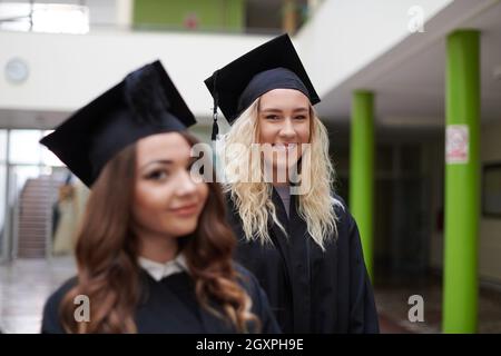 Istruzione, graduazione e concetto di persone - gruppo di felice gli studenti internazionali in mortaio e schede di corso di laurea gli abiti con diplomi Foto Stock