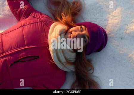 la ragazza si trova sulla neve e sorride. vista dall'alto. inverno russo Foto Stock