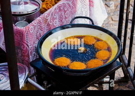 L'acarajé viene fritto in una teglia per olio dende. L'acarajé è una specialità gastronomica della cucina africana e afro-brasiliana. Salvador Bahia Brasile. Foto Stock