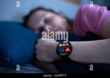 Smartwatch indossabile con monitoraggio della frequenza cardiaca in modalità sleep tracking a letto Foto Stock