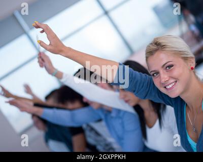 Gruppi studenti alzare le mani fino in aula Foto Stock