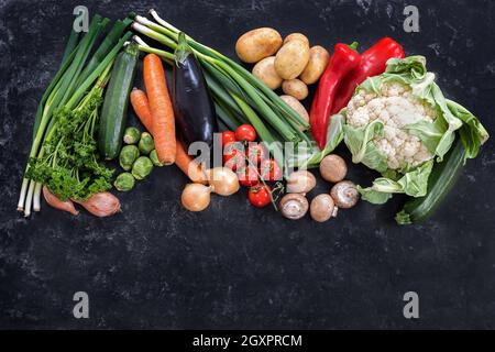 Verdure fresche di diverse varietà su uno sfondo scuro ardesia, dieta alimentare concetto per fitness e perdere peso, copia spazio, alto angolo di vista da ab Foto Stock