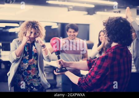 Multiethnics startup business team di sviluppatori di software divertimento mentre il pugilato a office,entusiasti diversi dipendenti ridere godendo di attività divertenti Foto Stock