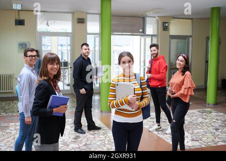 gli studenti si trovano nel corridoio della scuola presso un distanza dovuta alla pandemia del virus corona Foto Stock