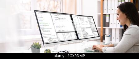 Coder Engineer che utilizza più monitor alla scrivania Foto Stock