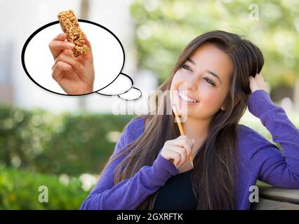 Malinconici donna con nutriente Snack Bar all'interno di bolle di pensiero. Foto Stock