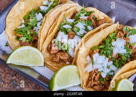 Tre autentiche bistecche messicane di taco con cipolle, coriandolo e lime Foto Stock