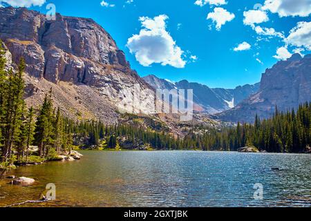 Grande lago vicino a montagne con pini Foto Stock