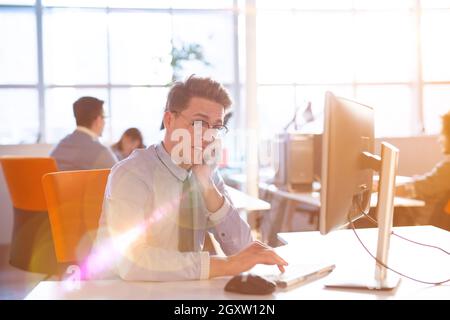Giovane imprenditore programer nella grande e luminosa office a lavorare utilizzando il computer Foto Stock