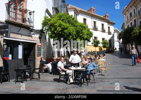 Persone che si rilassano in un caffè sul marciapiede nella città vecchia, Cordoba, Spagna. Foto Stock