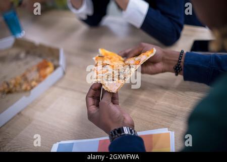 Amichevole multietnica diversi team aziendale la condivisione di mangiare la pizza insieme in ufficio di avvio, multirazziale i colleghi del gruppo del personale godendo di rompere parlando l Foto Stock