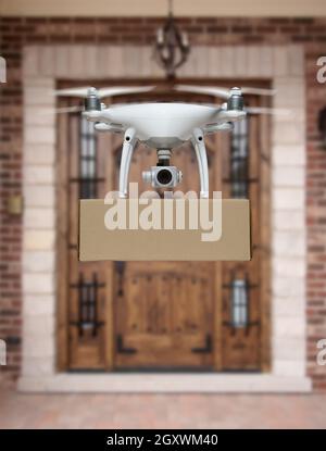 Unmanned Aircraft System (UAV) Quadcopter Drone consegna pacchetto a casa. Foto Stock