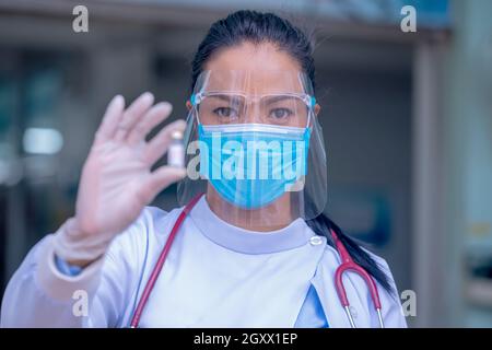 Primo piano medico o infermieri che mostrano flaconi di vaccino antivirale comprovati.medico che fornisce la vaccinazione profilattica HPV. Foto Stock