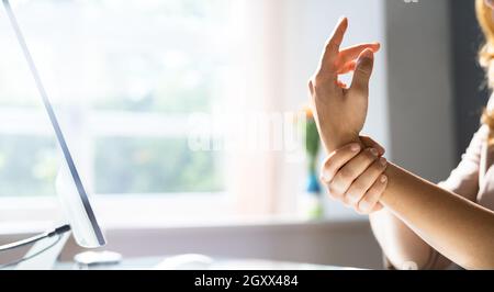 Giovane donna con dolore al nervo schiacciato presso l'ufficio Foto Stock