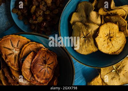 Ciotole di persimmon affettato, essiccato e disidratato e mela con uva passa Foto Stock