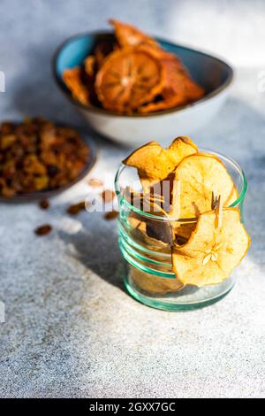 Ciotole di persimmon affettato, essiccato e disidratato e mela con uva passa Foto Stock