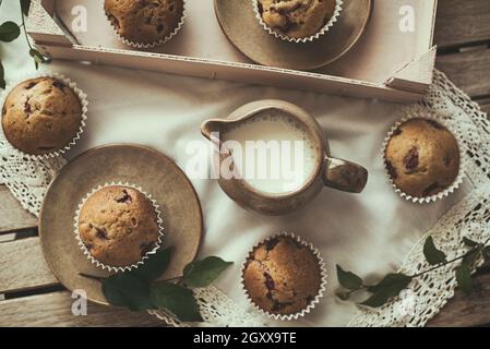 Vista dall'alto di sani muffin ai mirtilli e una caraffa per il latte su un tavolo Foto Stock