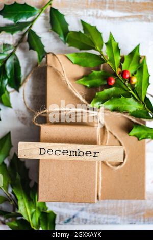 Due scatole regalo di Natale decorate con un fresco agrifoglio Foto Stock