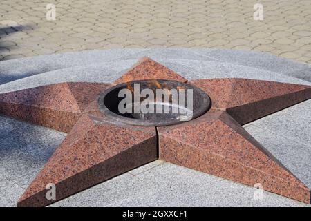 La masterizzazione di un fuoco eterno. Stella a cinque punte di granito monumento alla memoria dei soldati uccisi. Foto Stock