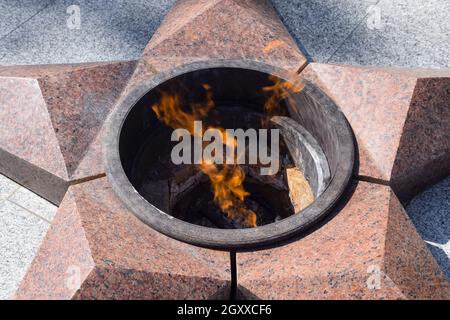 La masterizzazione di un fuoco eterno. Stella a cinque punte di granito monumento alla memoria dei soldati uccisi. Foto Stock