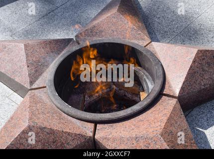 La masterizzazione di un fuoco eterno. Stella a cinque punte di granito monumento alla memoria dei soldati uccisi. Foto Stock