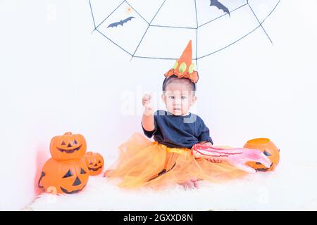 Divertente ragazza felice del bambino in costume di Halloween con Jack della zucca Con Cobweb sullo sfondo Foto Stock