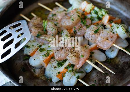 Pronti per cucinare spiedini di pesce con gamberi e calamari Foto Stock