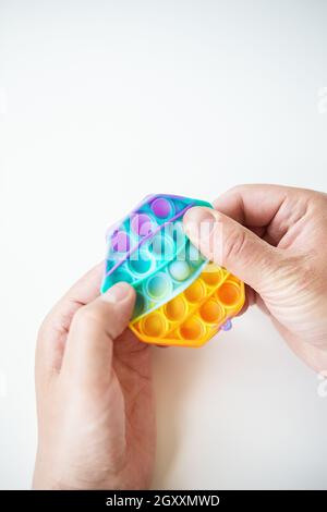 Il giocattolo sensoriale più alla moda. Popolare moda silicone colorato anti-stress esagonale pop esso giocattolo. Qualcuno preme su un giocattolo in silicone. Un giocattolo alla moda Foto Stock