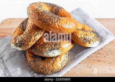 Alcuni deliziosi bagel con semi di papavero su un primo piano di tovagliolo. Vista frontale. Foto Stock