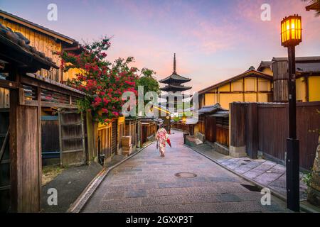 Ragazza giapponese a Yukata con ombrello rosso nella città vecchia di Kyoto, Giappone Foto Stock