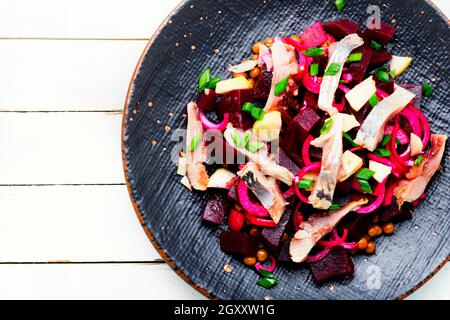 Insalata con aringhe, barbabietole, cipolle e piselli verdi. Cibo tedesco Foto Stock