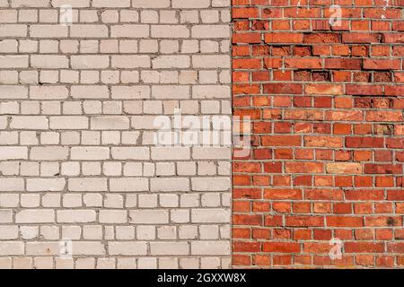 Parete in mattoni telaio completo con due sezioni di colori diversi. Muro di mattoni parzialmente bianco e parzialmente rosso . Foto Stock