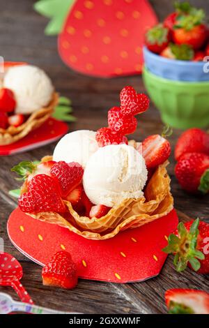 Gelato alla vaniglia con fragole fresche in tazze di waffle Foto Stock