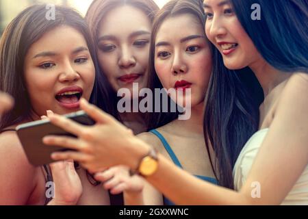 Foto di gruppo felice di amici in piedi guardando da parte fare un selfie. Amici felici che prendono le foto di riunione. Giovani sorridenti adolescenti che si divertono insieme Foto Stock