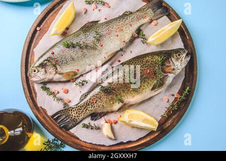 due trote arcobaleno grezze su carta con timo e limone. Trota di pesce. Vista dall'alto. Spazio libero per il testo Foto Stock