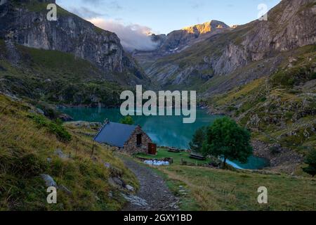 Rifugio di montagna dalla pietra su un lago di montagna nei Pirenei del Lac des Gloriettes - Francia Foto Stock