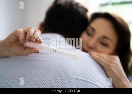 Felice coppia con il test di gravidanza. I genitori sono molto contenti Foto Stock