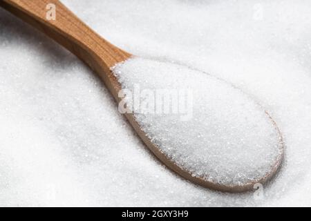 cucchiaio di legno con sostituto zucchero - estratto cristallino di stevia pianta primo piano su palo Foto Stock