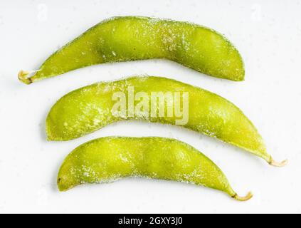 Diversi edamame surgelati (soia non matura) le cialde si avvicinano alla piastra in ceramica grigia Foto Stock