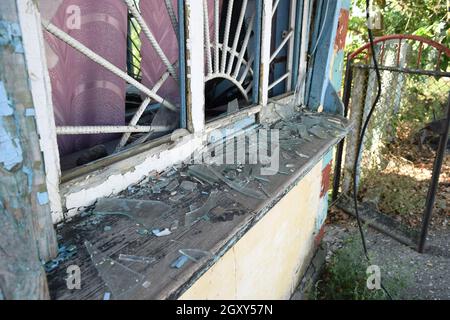 Le finestre con i vetri rotti. Il vecchio buttato gas station. Foto Stock