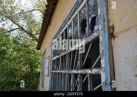 Le finestre con i vetri rotti. Il vecchio buttato gas station. Foto Stock